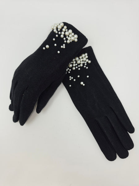 A pair of black knit gloves decorated with white faux pearls and rhinestones around the cuffs, displayed on a light gray background.