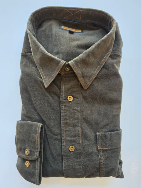 A folded dark gray chambray button-down shirt with brass buttons and a pointed collar, shown against a light blue background.
