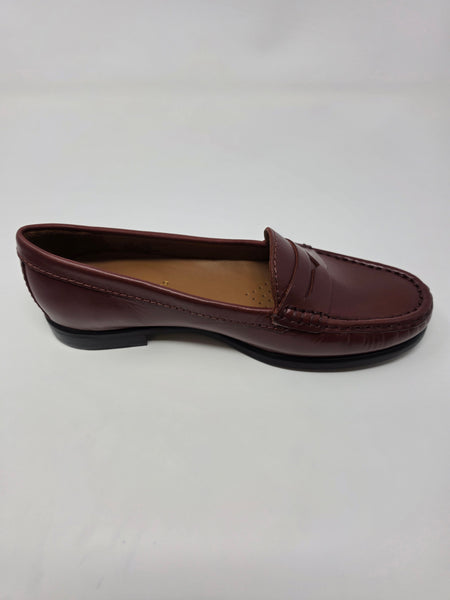 A single burgundy leather penny loafer shown in profile against a plain white background.