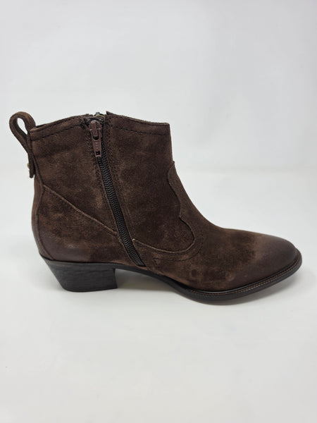 A dark brown suede ankle boot with a side zipper, low block heel, and pull tab, shown from a side profile on a light gray background.