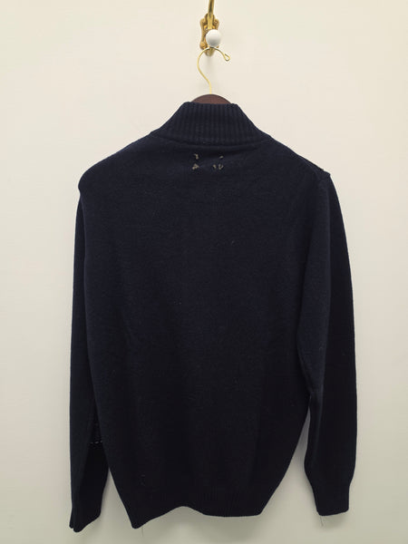 A dark navy blue knit sweater with a ribbed mock neck collar, displayed flat against a plain off-white background.