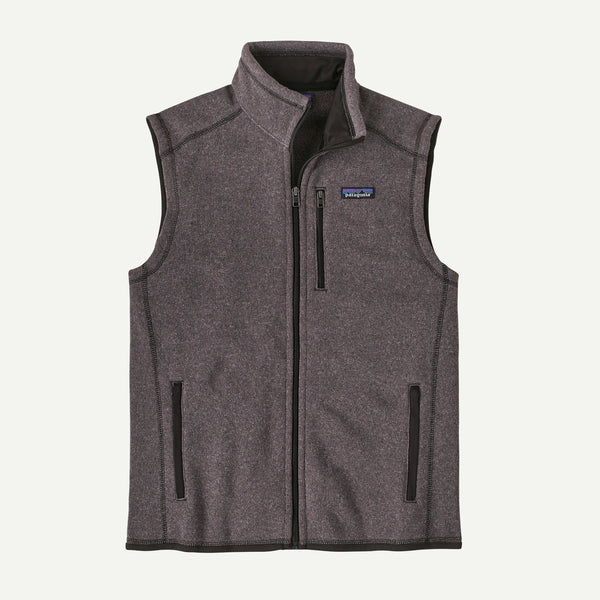 A dark heather gray fleece vest with a full-zip front, stand-up collar, and zippered hand pockets, shown against a light off-white background. The Patagonia logo is visible on the chest.