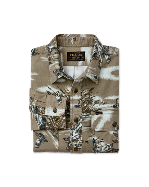 A folded Filson button-up shirt in a tan and brown earth-tone camouflage pattern with bird and leaf motifs, displayed on a clean white background.