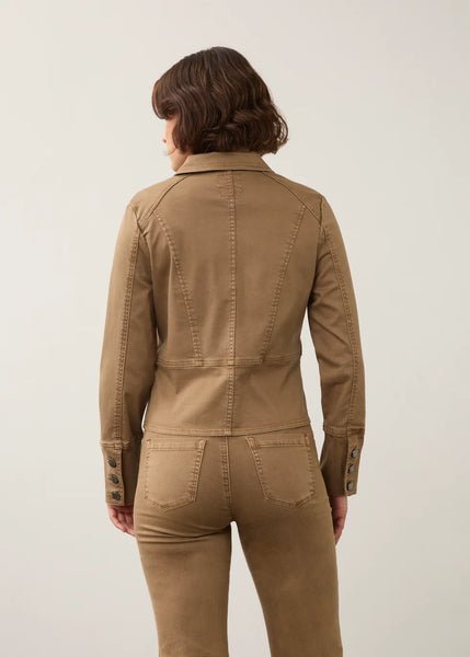 A woman shown from the back wearing a fitted tan utility jacket and matching tan pants against a plain light gray studio background.