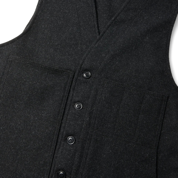 Close-up of a dark charcoal gray sleeveless button-front vest or cardigan with a V-neckline and front flap pockets, shown on a white background.