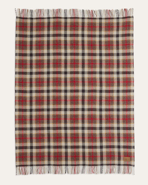 A rectangular plaid scarf with fringed edges, featuring a beige base with red and black tartan checks, displayed flat against a light off-white background.