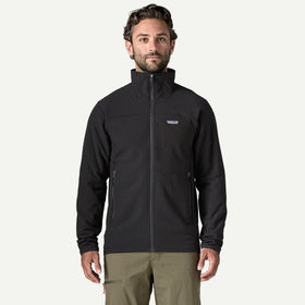 A man wearing a black Patagonia full-zip fleece jacket with a stand-up collar and zippered hand pockets, paired with khaki pants, against a plain white background.