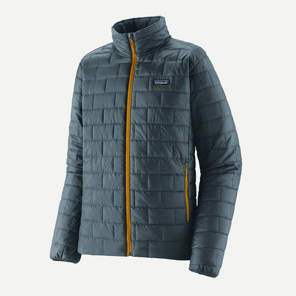 A Patagonia quilted puffer jacket in slate blue-gray with a yellow-gold front zipper and matching zipper pocket, shown on a light off-white background.