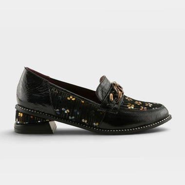 A single women's loafer-style shoe shown in side profile on a light gray studio background. The upper is primarily deep burgundy leather with a floral embroidered panel in black, pink, and white, plus a small gold-tone decorative accent near the vamp.