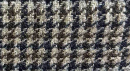 A close-up of a woven fabric texture with a houndstooth pattern in dark navy, brown, and beige.