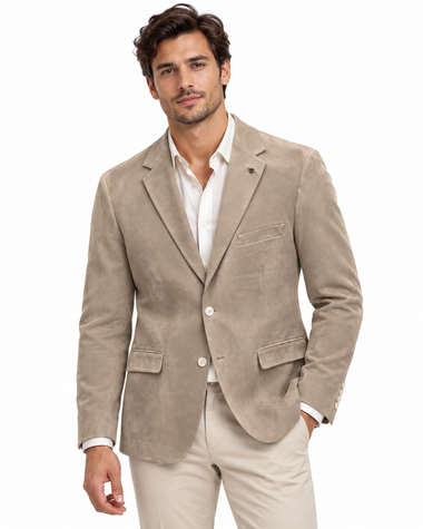 A man wearing a light beige corduroy blazer over a white dress shirt and beige trousers, photographed against a plain white background.
