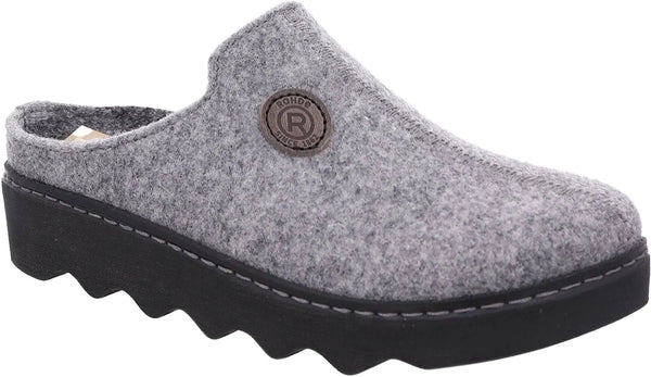 A gray felt clog shoe with a black wavy sole and a circular metal brand badge on the side.
